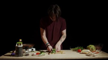 Mutfakta bir şef, tezgahta taze malzemelerle çevrili shawarma yapmak için maydanozu ustaca doğruyor. Yavaş çekim