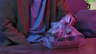 Evde Asya fast food 'unun tadını çıkarıyorum. Genç adam akşamları kanepede oturur, lezzetli Asya yemekleri sipariş eder, paketleri alır ve masaya koyar, sipariş edilen yiyecek ve içecekleri kontrol eder..