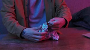 Evde Asya fast food 'unun tadını çıkarıyorum. Genç adam akşamları kanepede oturuyor, lezzetli Asya yemeği siparişi veriyor, plastik kaseden kepçeyle kaplı folyoyu çıkarıyor..