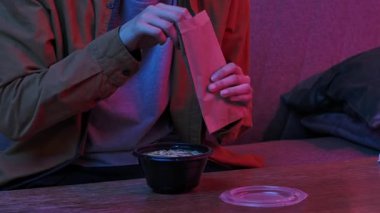 Evde Asya fast food 'unun tadını çıkarıyorum. Genç adam akşamları kanepede oturur, lezzetli Asya yemekleri sipariş eder, kaşık ve makarnayı plastik kasede miso çorbasıyla karıştırır..