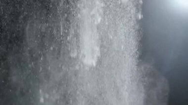 Dumanlı havada rastgele uçan küçük toz bulutu, nesneler için boş uzay şablonu. Birçok toz parçacığı beyaz toz spot ışıklarıyla boş siyah kontrast arka planına düşüyor. Yavaş çekim.