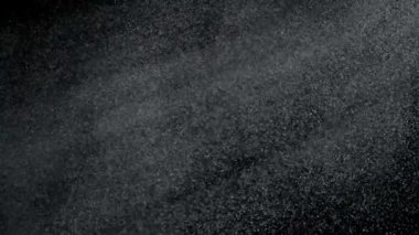 Dumanlı havada rastgele uçan küçük toz bulutu, nesneler için boş uzay şablonu. Birçok toz parçacığı beyaz toz boş siyah kontrast arka planda süzülüyor ışık ışınlarında. Yavaş çekim.