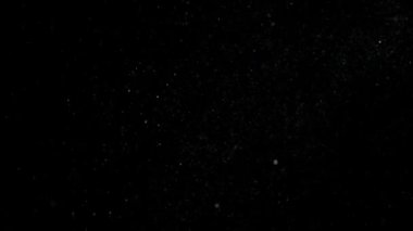 Dumanlı havada rastgele uçan küçük toz bulutu, nesneler için boş uzay şablonu. Birçok sim parçacığı ışık huzmelerinde boş siyah kontrastlı arka planda yüzer. Yavaş çekim.