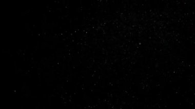 Dumanlı havada rastgele uçan küçük toz bulutu, nesneler için boş uzay şablonu. Birçok sim parçacığı ışık huzmelerinde boş siyah kontrastlı arka planda yüzer. Yavaş çekim.