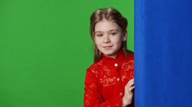 Çocuk duyguları reklam konsepti. Gülümseyen kız el sallıyor ve buraya geliyor. Jest, pozitif ifade, krom anahtar yeşil ekranda izole edilmiş arka plan modeli..