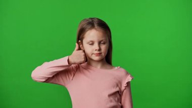 Çocuk duyguları reklam konsepti. Gülümseyen kız kameraya bakar ve el işaretini gösterir, olumlu ifade, krom anahtar yeşil ekran arka plan modelinde izole edilmiş.