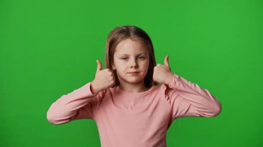 Çocuk duyguları reklam konsepti. Gülümseyen kız kameraya bakar ve el işaretlerini, olumlu ifadeyi gösterir. Krom anahtar yeşil ekran arka plan modelinde izole edilmiştir..