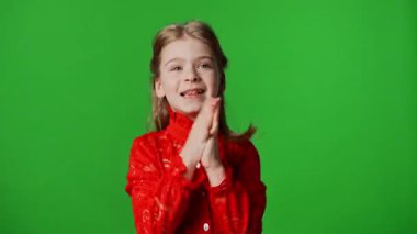 Çocuk duyguları reklam konsepti. Gülümseyen kız çocuğu, kazanan jestler ve mutlu pozitif ifade sergiliyor. Krom anahtar yeşil ekran stüdyo arka planında izole edilmiş..