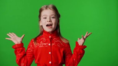 Çocuk duyguları reklam konsepti. Şaşırmış gülümseyen kız çocuğu kameraya bakar tokalaşır, olumlu ifade verir, krom anahtar yeşil ekran arka plan modelinde izole olur..