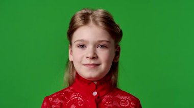 Çocuk duyguları reklam konsepti. Kırmızı tişörtlü küçük kız kameraya bakıyor ve gülümsüyor. Renkli anahtar yeşil ekran arka plan modelinde izole edilmiş..