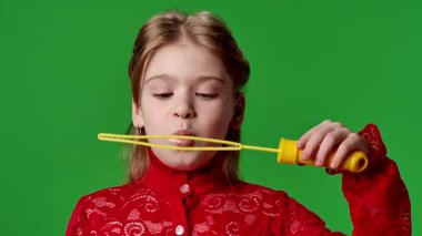 Çocuk duyguları reklam konsepti. Sabun köpüğü yapıcı içinde gülen kız, etrafta uçuşan baloncuklar, pozitif ifade, krom anahtar yeşil ekranda izole edilmiş arka plan modeli..