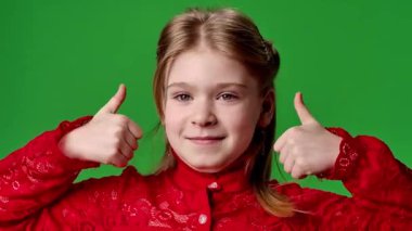 Çocuk duyguları reklam konsepti. Gülümseyen kız kameraya bakar ve el işaretlerini, olumlu ifadeyi gösterir. Krom anahtar yeşil ekran arka plan modelinde izole edilmiştir..