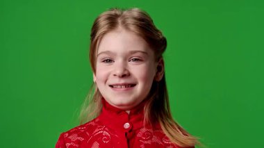 Çocuk duyguları reklam konsepti. Gülümseyen kız kameraya bakar ve hava öpücüğü verir, gülümser, pozitif ifade, krom anahtar yeşil ekranda izole edilmiş arka plan modeli..