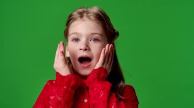 Çocuk duyguları reklam konsepti. Gülümseyen kız çocuğu hayret verici bir şekilde çığlık atıyor ve el çırpıyor. pozitif ifade, krom anahtar yeşil ekran stüdyo arka plan modeli izole.