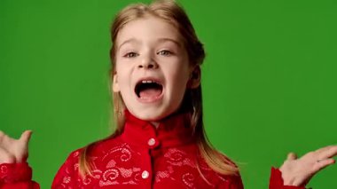 Çocuk duyguları reklam konsepti. Şaşırmış gülümseyen kız çocuğu kameraya bakar tokalaşır, olumlu ifade verir, krom anahtar yeşil ekran arka plan modelinde izole olur..