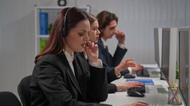 Bilgisayar başında çalışan profesyonel çağrı merkezi ajanlarından oluşan bir ekip uzman müşteri hizmetleri ve destek sunuyor..