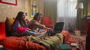 Genç bir kadın ve erkeğin eski bir gramofonla müzik dinlediği canlı bir sahne..