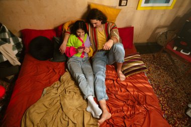 Genç bir çift sıcak, samimi bir anı paylaşır. Samimi bir ortamda sevgi ve yakınlığı yansıtır. Üst çekim