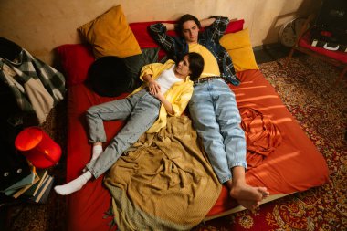 Genç bir çift sıcak, samimi bir anı paylaşır. Samimi bir ortamda sevgi ve yakınlığı yansıtır. Üst çekim