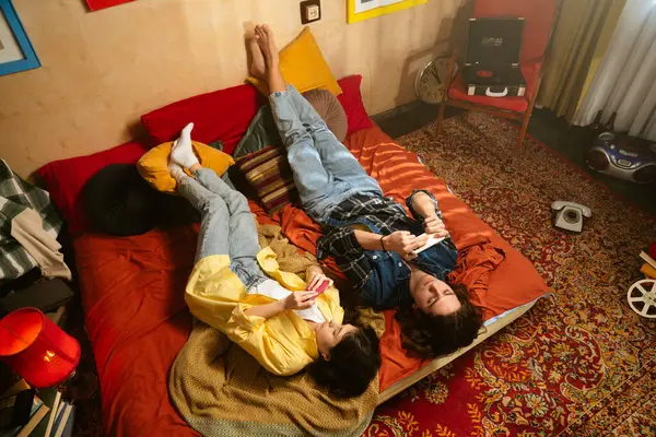 Bir çift renkli eski moda bir odada rahat bir anın tadını çıkarıyor. İçkilerini yudumluyor ve telefon kullanıyor. Üst çekim