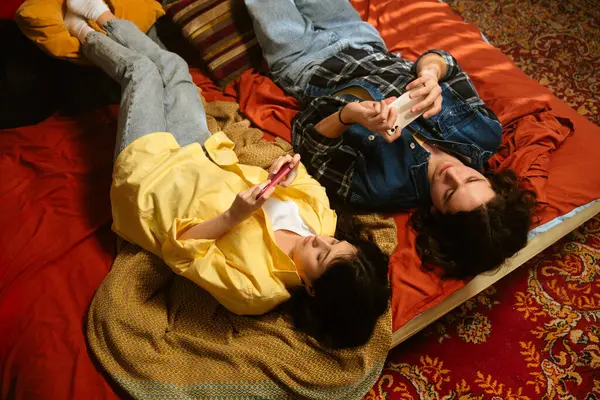 Bir çift renkli eski moda bir odada rahat bir anın tadını çıkarıyor. İçkilerini yudumluyor ve telefon kullanıyor. Üst çekim