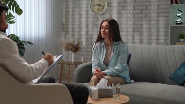 Günlük yaşam tarzı konsepti. Yaşlı yetişkin kadın zihinsel tedavi görüyor, kadın psikoterapiste gidiyor, kanepede oturuyor doktor notlar yazıyor. Yavaş çekim