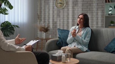 Günlük yaşam tarzı konsepti. Yaşlı yetişkin kadın zihinsel tedavi görüyor, kadın psikoterapiste gidiyor, kanepeye oturuyor, sorunlarını anlatıyor, doktorla konuşurken üzülüyor. Yavaş çekim