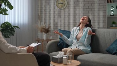 Günlük yaşam tarzı konsepti. Yaşlı yetişkin kadın zihinsel tedavi görüyor, kadın psikoterapiste gidiyor, kanepeye oturuyor, sorunlarını anlatıyor, ağlayan surat ifadeleri takınıyor. Yavaş çekim