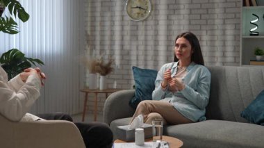 Günlük yaşam tarzı konsepti. Yaşlı yetişkin kadın zihinsel tedavi görüyor, kadın psikoterapiste gidiyor, kanepede oturuyor doktorla konuşuyor, soruları cevaplıyor. Yavaş çekim