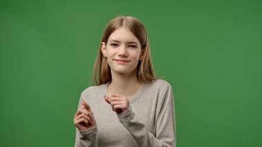 Gençlik duyguları konsepti. Kameraya poz veren genç kız gülümseyen ve dans eden komik dans eden, pozitif ifade, krom anahtar yeşil ekran arka plan modelinde izole edilmiş..
