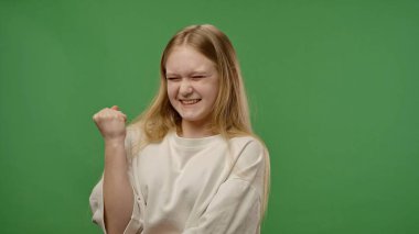 Gençlik duyguları konsepti. Genç kız heyecanla kameraya poz veriyor, olumlu jest yapıyor, yeşil ekran arka plan modelinde izole edilmiş..
