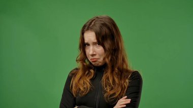 Gençlik duyguları konsepti. Çapraz kollar ve ağlayan surat ifadesiyle kameraya poz veren genç kız, krom anahtar yeşil ekranlı arka plan modelinde izole edilmiş..