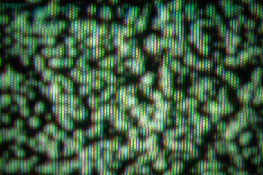 Çarpık bir TV ekranında renkli pikselleri yakalayan, kaotik ve sanatsal bir görüntü gösteren yakın plan bir resim..