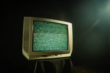 Ekranında, loş bir odada, nostalji uyandıran statik sesleri gösteren klasik bir televizyon seti..