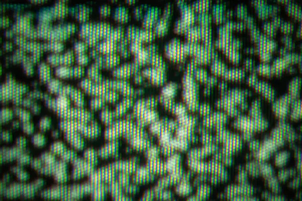 Çarpık bir TV ekranında renkli pikselleri yakalayan, kaotik ve sanatsal bir görüntü gösteren yakın plan bir resim..