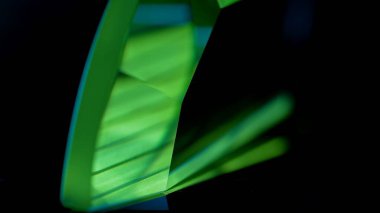 Simsiyah bir zemin karşısında koyu yeşil renkli geometrik şekiller gösteren canlı ve soyut bir görüntü çarpıcı bir görsel karşıtlık yaratıyor. Makro