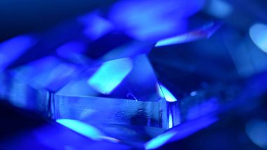 Canlı mavi bir kristalin karmaşık bir yakın çekimi soyut yönlerini ve parlak yansıtıcı yüzeylerini sergiliyor. Makro