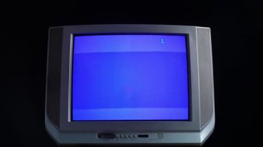 Klasik bir CRT televizyonu mavi ekran gösteriyor, sinyal yok. Görüntü nostaljik bir retro cihazı yakalıyor..