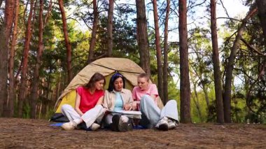 Üç arkadaş ormanda kamp yaparken heyecan verici bir an yaşadılar, bir çadırın etrafında toplandılar..