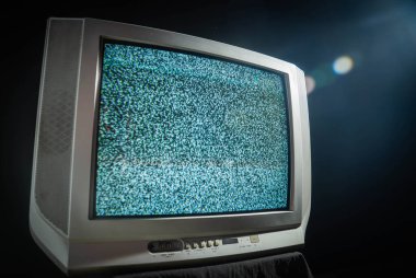 Klasik bir analog televizyon seti statik gürültüyü gösteriyor, teknolojik nostaljiyi ve estetiği vurguluyor.