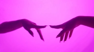 Büyüleyici sanatsal bir görüntü. İki el canlı pembe bir arkaplana uzanıyor..