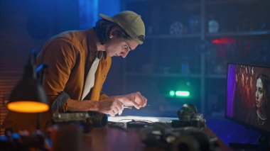 Odaklanmış genç bir teknisyen hassas aletlerle donatılmış elektronik parçalar üzerinde titizlikle çalışır..