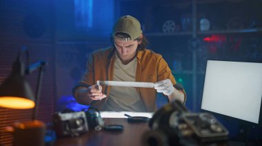 Bir insan yüksek teknoloji laboratuvarında cetvelli bir objeyi dikkatlice ölçer, hassasiyet ve detaylara odaklanır..