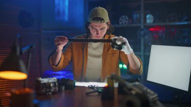 Bir insan yüksek teknoloji laboratuvarında cetvelli bir objeyi dikkatlice ölçer, hassasiyet ve detaylara odaklanır..