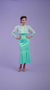 Klasik kıyafetli, çekici saç stili olan genç bir kadın mor stüdyo geçmişinde poz veriyor. Eski tarz güzel bir aktris kameraya bakarken mutlu bir şekilde göz kırpar. Güzellik konsepti ve klasik tarzı.