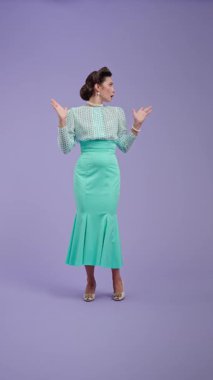 Klasik kıyafetli, çekici saç stili olan genç bir kadın mor stüdyo geçmişinde poz veriyor. Retro tarzında güzel bir aktris hoşnutsuzluk duygusunu ifade eder. Güzellik ve eski tarz konsept.