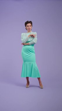 Klasik kıyafetli, çekici saç stili olan genç bir kadın mor stüdyo geçmişinde poz veriyor. Retro tarzı düşünen güzel bir aktris, sonra güzel bir fikir geliyor. Güzellik ve eski tarz konsept