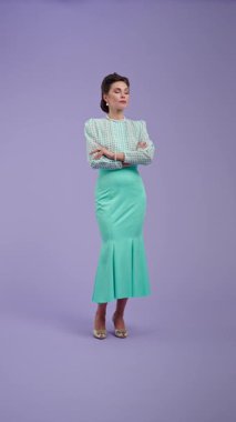 Klasik kıyafetli, çekici saç stili olan genç bir kadın mor stüdyo geçmişinde poz veriyor. Retro tarzında güzel bir aktris. Taraf görmüş ve mutlu bir şekilde şaşırmış. Güzellik ve eski tarz konsept.