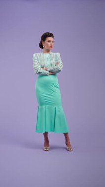 Klasik kıyafetli, çekici saç stili olan genç bir kadın mor stüdyo geçmişinde poz veriyor. Retro tarzında güzel bir aktris kızgın. Güzellik ve eski tarz konsept.