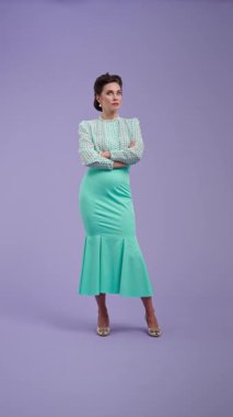 Klasik kıyafetli, çekici saç stili olan genç bir kadın mor stüdyo geçmişinde poz veriyor. Retro tarzında güzel bir aktris kızgın. Güzellik ve eski tarz konsept.